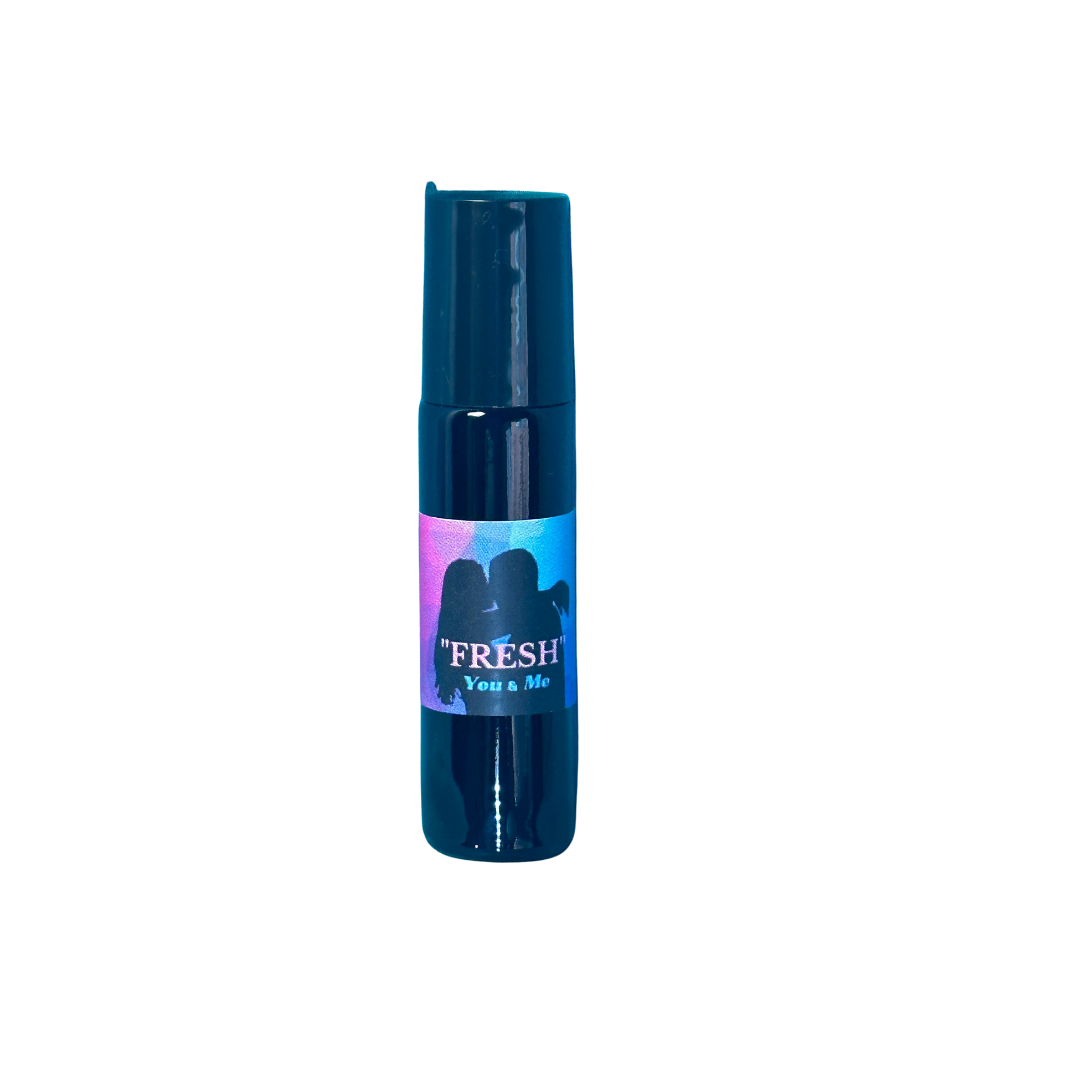 Fresh all natural perfume in a 10 ml roll-on has a label showing the sillouette of a woman with long hair and main with short hair embracing in a kiss. The background is pink, purple and blue. Under the word Fresh is the phrase "You and Me" as this is part of a Collection built to celebrate romance. Fresh is the first in this Collection.